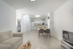 A modern living room with a sofa, a coffee table, and a TV. - Casa Valdebek With Pool (Pula)