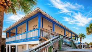 A beachfront building with a wooden staircase leading to a covered area, columns, and a clear sky. - Stylish 2BR/2BA coastal getaway to 7 Min Drive to Beach "Crystal Bay Stays" (Englewood)