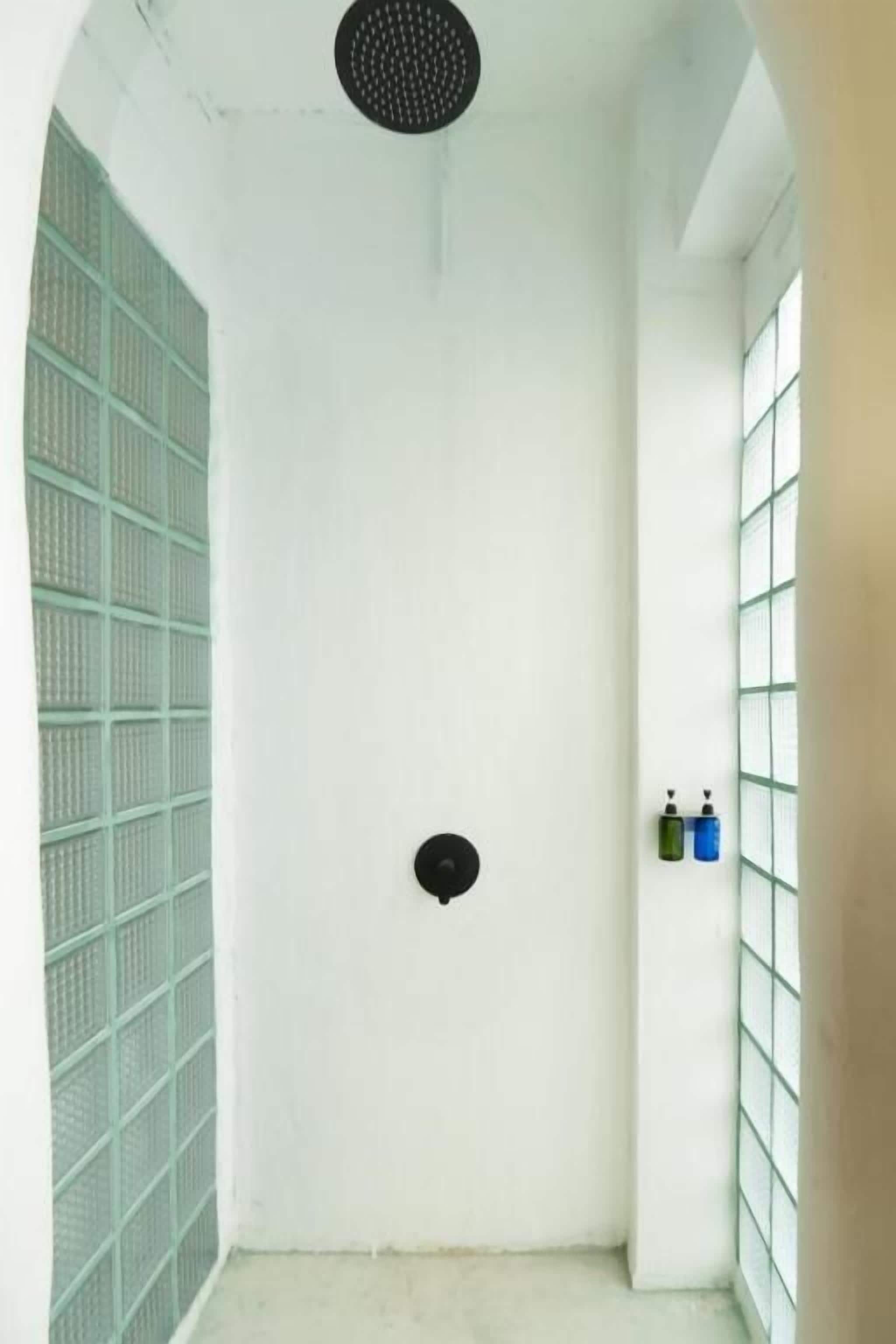 A bathroom with a shower, a toilet, and a sink.