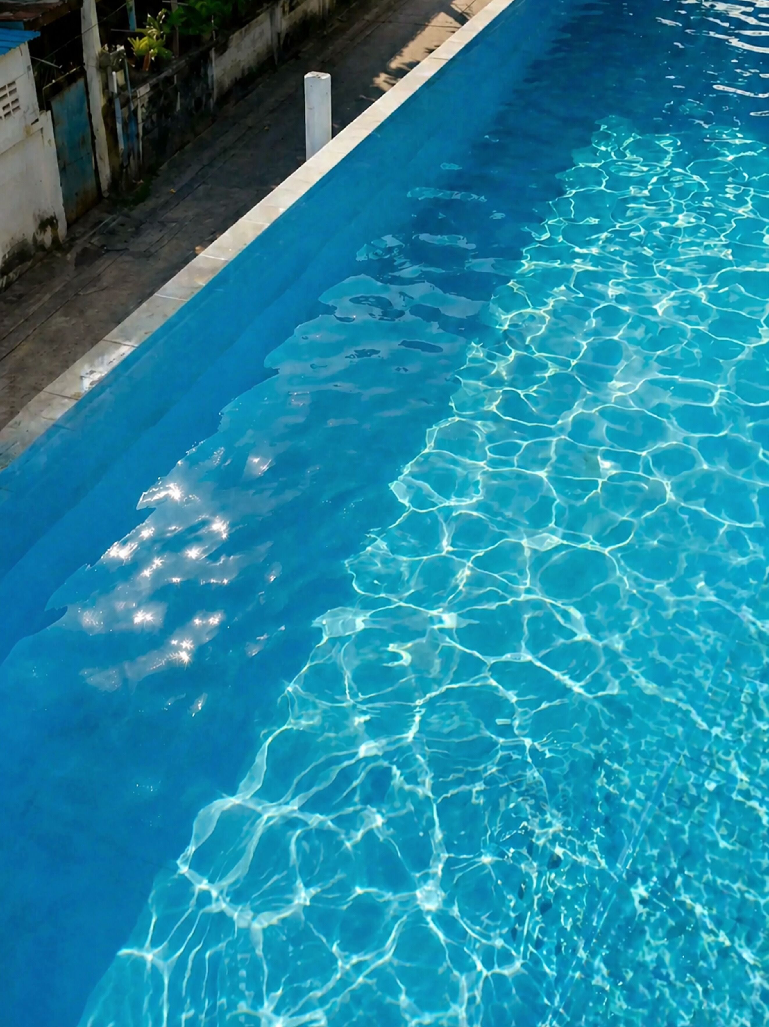 Ein Schwimmbecken mit klarem, blauem Wasser und einer gefliesten Kante.