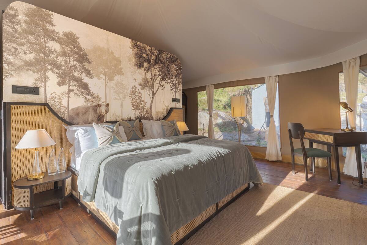 Une chambre avec un grand lit, un bureau et une vue sur l’extérieur.