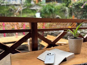 A wooden table with a smartphone, a book, and a potted plant.