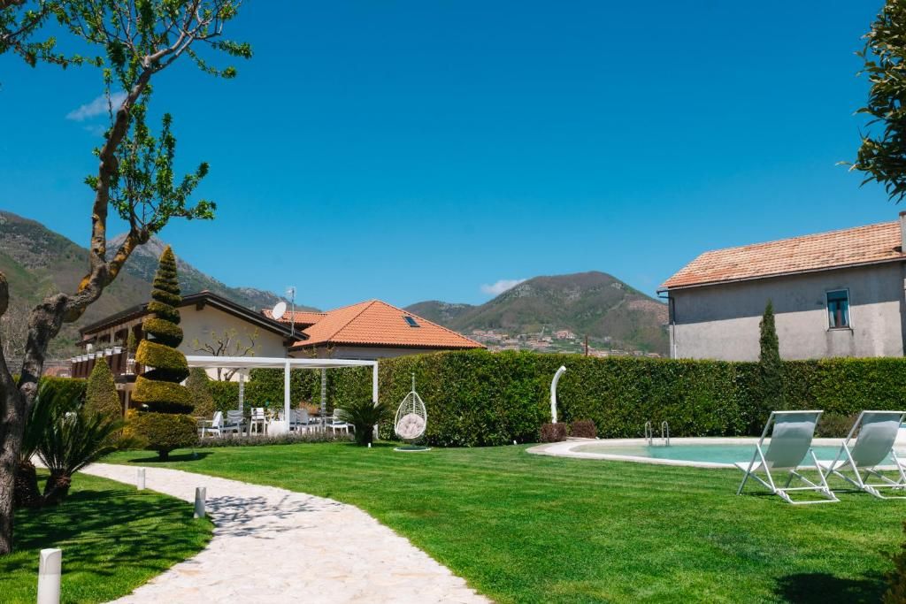 Un espacio exterior bien cuidado con piscina, sillas de descanso y vistas despejadas de las montañas circundantes.