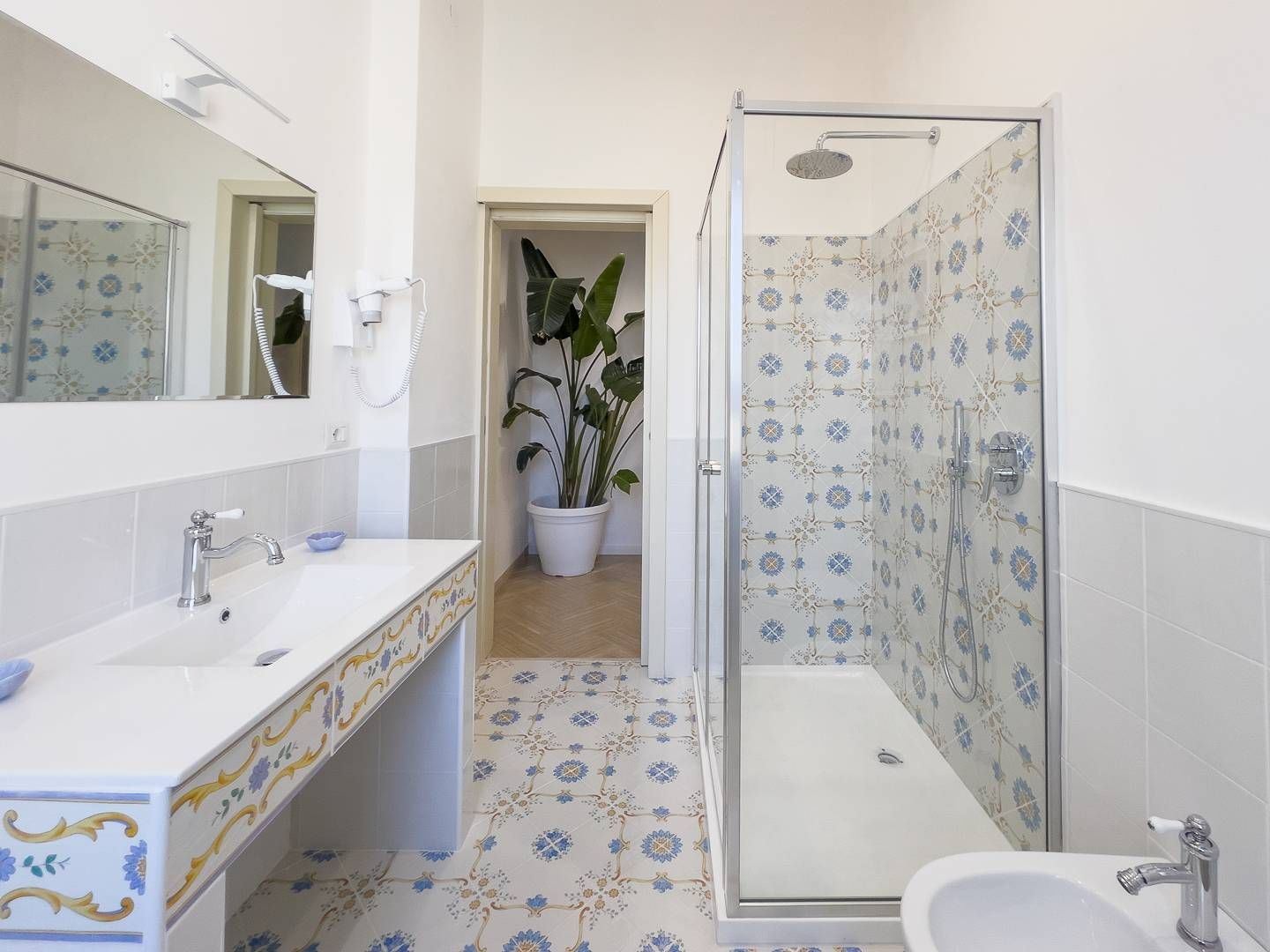 A bathroom with a shower, a sink, and a mirror.