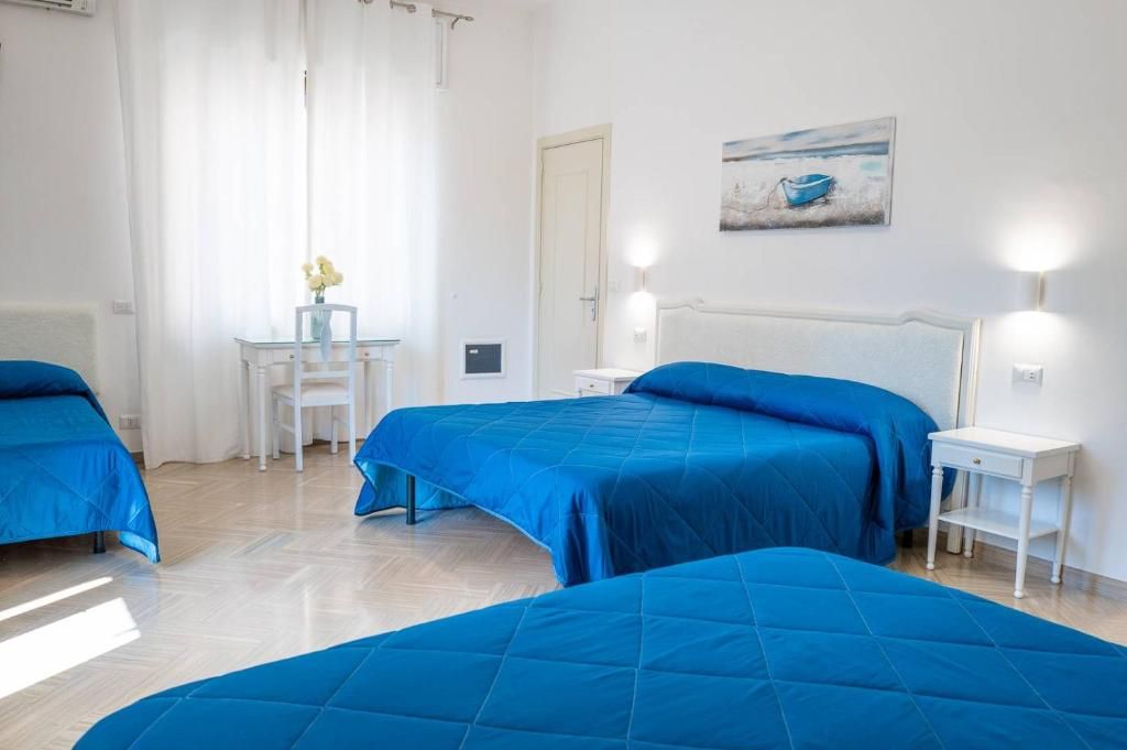 Ein Hotelzimmer mit zwei Betten, einem Schreibtisch und einem Stuhl.