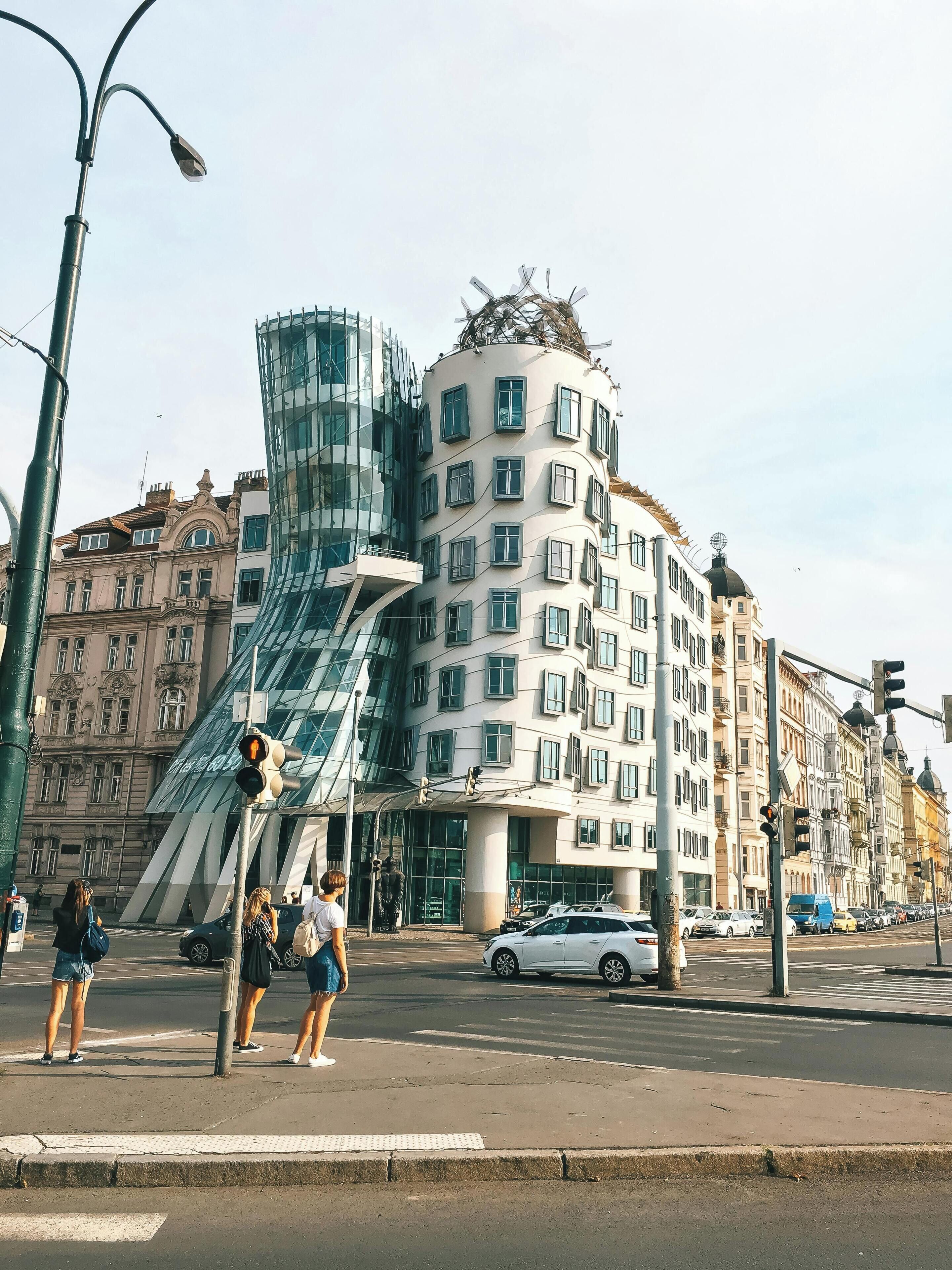 A modern building with a unique curved glass facade and traditional architecture.