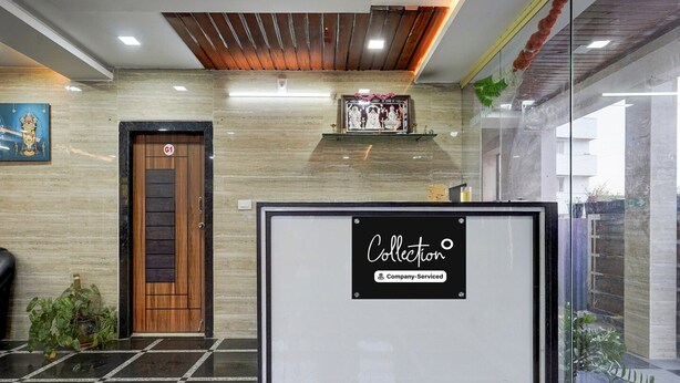 A reception area with a wooden door, a framed sign, and a tiled floor. - Deluxe Mini Bypass Nellore Road (Nellore)