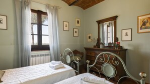 Une chambre avec deux lits, une commode et un miroir.