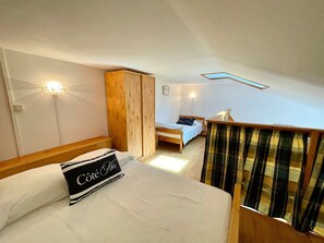 Una camera da letto con un letto, un armadio, un comodino e una finestra con tende.