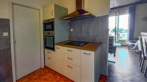 Cuina compacta amb forn integrat, microones i fogó.