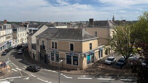 A street view with buildings, a clear sky, and parked cars. - Chic city center studio, parking - 2 guests (Sablé-sur-Sarthe)