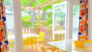 A room with a view of greenery and a wooden deck outside. - Mobile home, AC - 5 guests (Sainte-Marie)