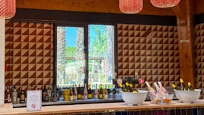 A bar area with bottles, a sign, and yellow chairs. - Mobile home, AC - 5 guests (Sainte-Marie)