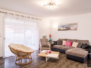 Ein Wohnzimmer mit einer Couch, einem Sessel, einem Couchtisch und einem Bild an der Wand.