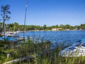 A marina with boats docked, surrounded by greenery and buildings in the background. - Duplex near the lake - 6 guests (Biscarrosse)