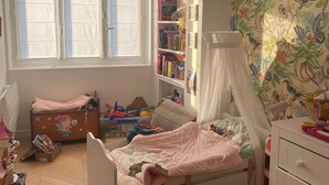 A child's bedroom with a bed, a bookshelf, a window, and a wall with a bird pattern. - Apartment PARIS 1 MINUTE WALKING TO TOUR EIFFEL (Paris)