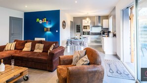 Ein modernes Wohnzimmer mit einem braunen Sofa, einem Couchtisch und einer blauen Akzentwand.