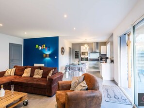 Ein modernes Wohnzimmer mit einem braunen Sofa, einem Couchtisch und einer blauen Akzentwand.