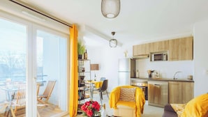 A modern apartment with a dining area, kitchen, and a balcony with outdoor seating. - Cozy apartment in the heart of Biscarrosse - 4 guests (Biscarrosse)