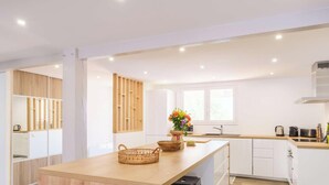 Een moderne keuken met houten kastjes, een centraal eiland en een raam voor natuurlijk licht.