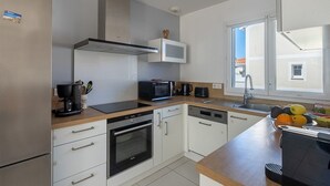 Eine moderne Küche mit Herd, Mikrowelle und Spüle.