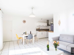A modern living space with a dining area, kitchen, and a grey sofa. - House near lake - 5 guests (Biscarrosse)