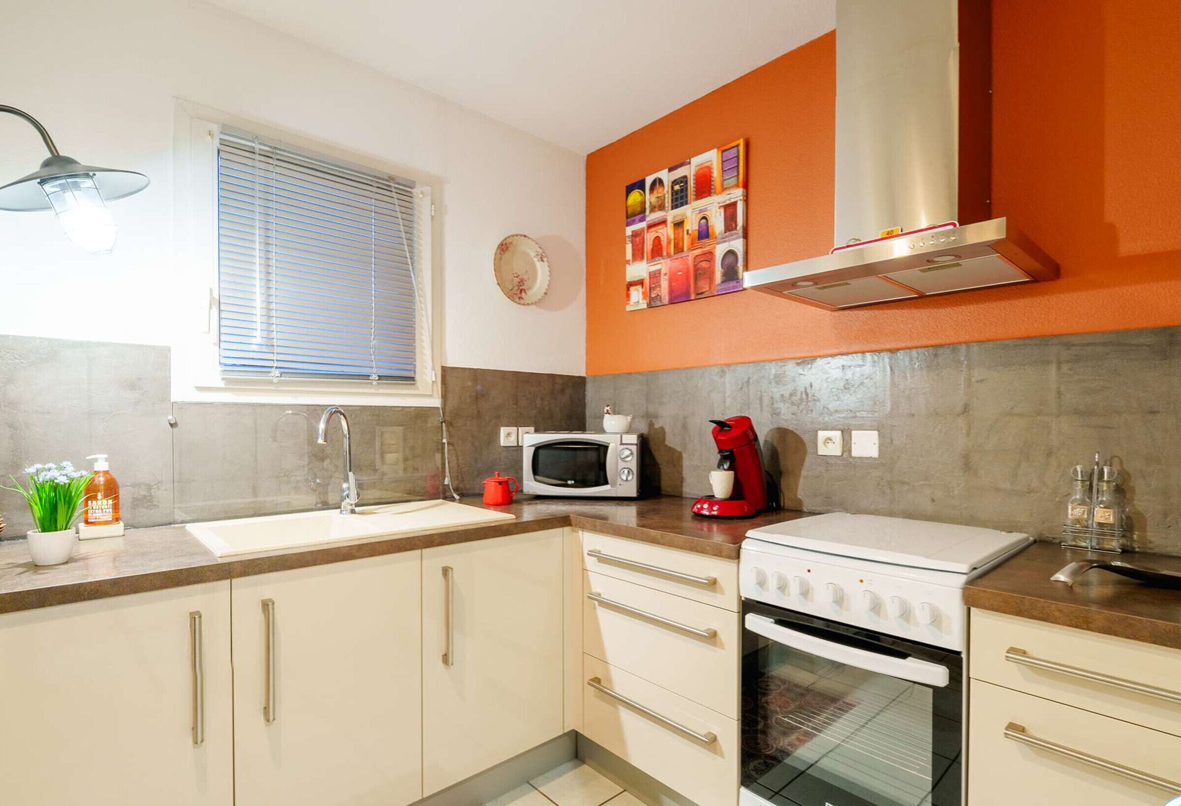 A kitchen with a sink, microwave, coffee maker, and stove.