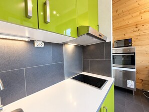A modern kitchen with a built-in stove, a microwave, and an oven. - Apartment with mountain view - 4 guests (Les Menuires)
