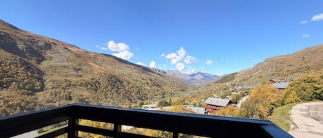 Un balcón con vista a un valle y montañas.