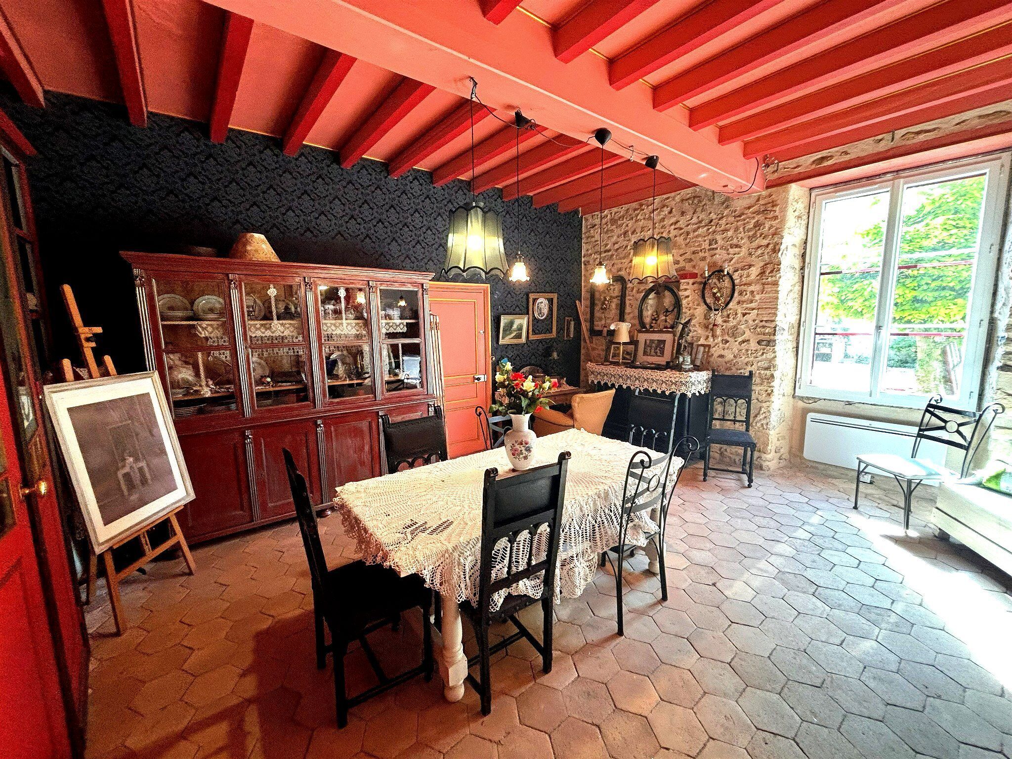 A dining area with a table, chairs, a cabinet, and a window with a view.