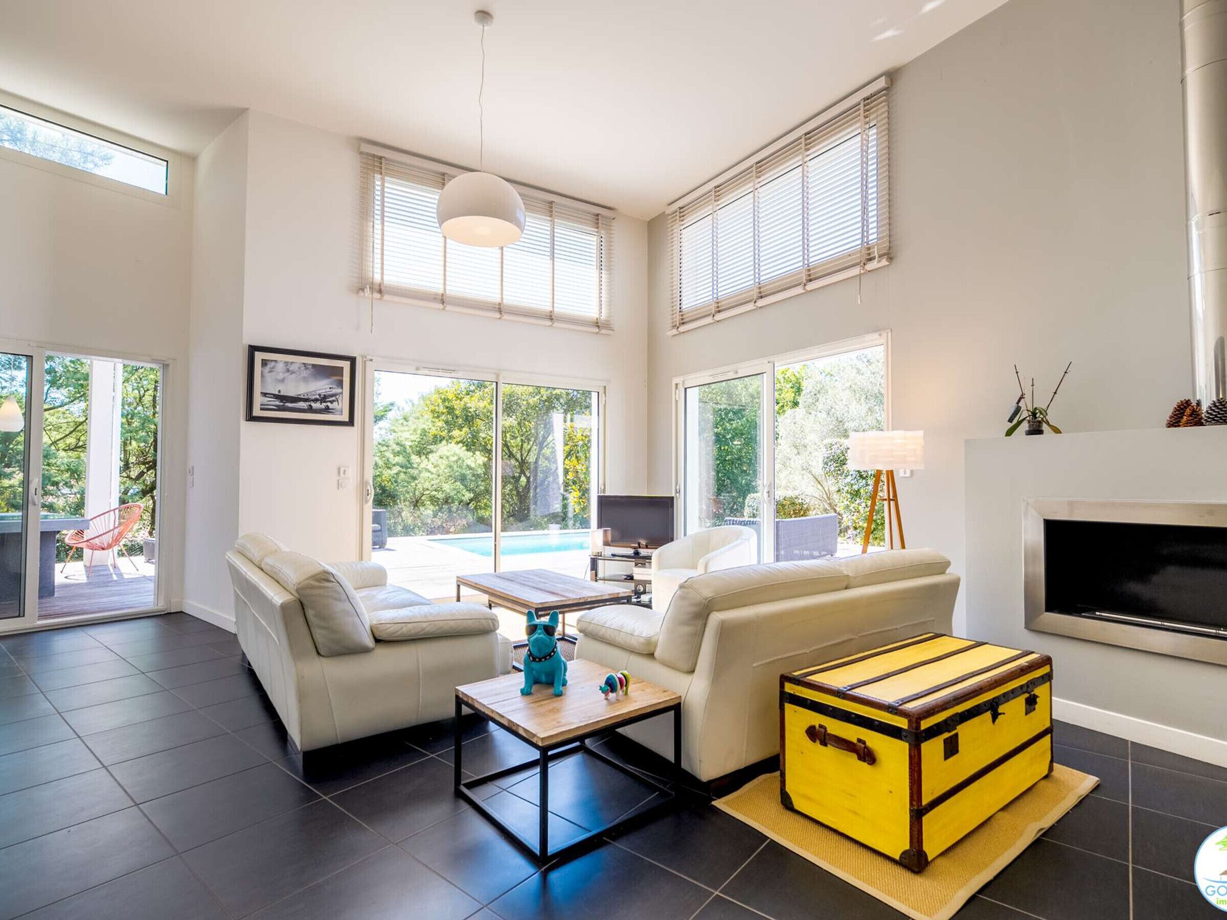 Een moderne woonkamer met een bank, salontafel en een gele koffer.
