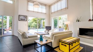A modern living room with a sofa, coffee table, and a yellow trunk.