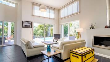 Een moderne woonkamer met een bank, salontafel en een gele koffer.