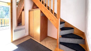 A wooden staircase with a handrail, a wooden wardrobe, and a mirror on the wall. - Comfortable duplex, slope view - 6 guests (Valfréjus)