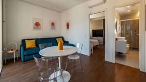 Ein modernes Wohnzimmer mit einem runden Tisch, einem blauen Sofa und einer Glastrennwand.