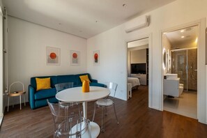 A modern living room with a round table, a blue sofa, and a glass partition. - A comfortable and welcoming 48 square meters apartment, perfect for two people, located on the fifth and top floor of a building with an elevator (NOT accessible to disabled guests).The property is located very close to Rome Tiburtina Station (400 meters (Rome)