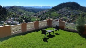 Un balcón con vistas a un pueblo y colinas.