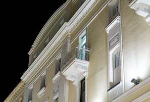 Ein mehrstöckiges Gebäude mit klassizistischen architektonischen Details, darunter aufwendige Balkone und dekorative Gesimse.