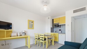 A compact living space with a dining area, kitchenette, and a sofa. - Renovated flat near the town centre & swimming pool (Grasse)
