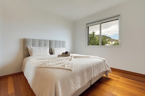 Une chambre à coucher avec un lit, une fenêtre et une vue sur une colline.