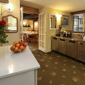 A kitchen with a fruit bowl on the counter, a dining area with a table and chairs, and a view of the dining area through an open door. - escape the ordinary rooms - dinning, living, al fresco, 4 double all en-suite (Piddletrenthide)