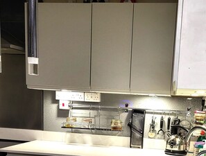 A kitchen with stainless steel cabinets, a countertop with a kettle, and various kitchen utensils. - escape the ordinary rooms - dinning, living, al fresco, 4 double all en-suite (Piddletrenthide)