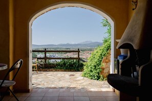 Eine Außenpatio mit Steinboden, Holzzaun und Blick auf Stadt und Berge.