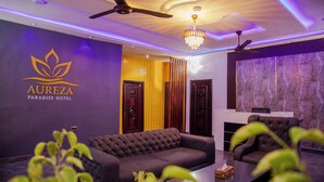 A modern hotel lobby with a sofa, a chandelier, and a reception desk. - Aureza Paradise Hotel (Tamale)