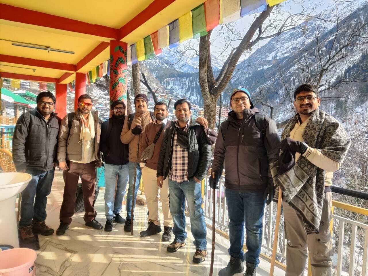 A group of people standing on a terrace with a mountain view.