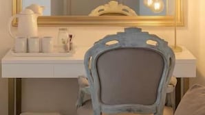 A vanity with a large mirror, a lamp, and toiletries on the counter.