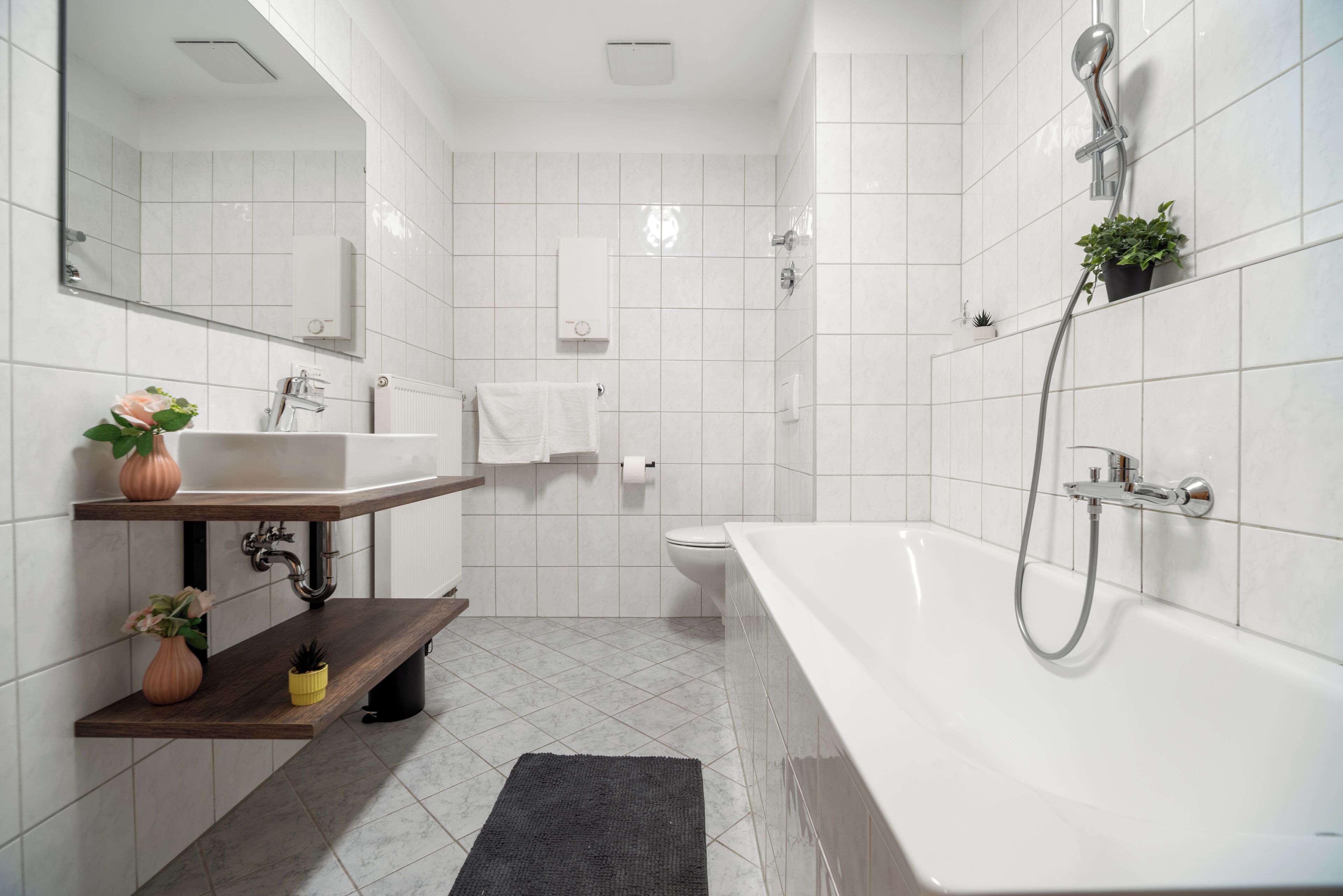 Un baño moderno con bañera, lavamanos, inodoro y ducha.