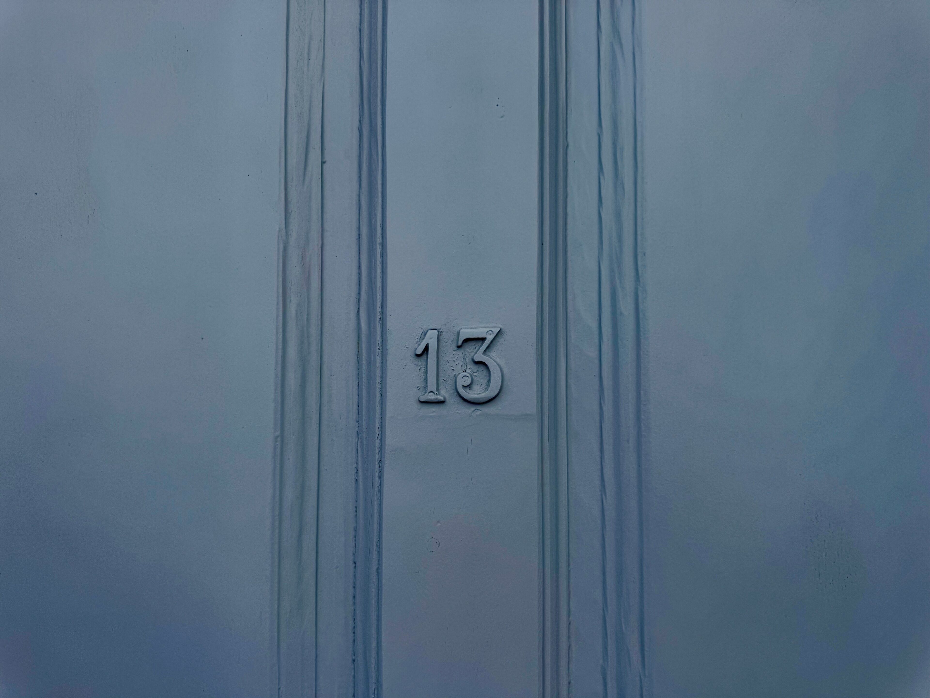 Ein Detailaufnahme einer Wand mit der Zahl '13' in Metalloptik eingeprägt.