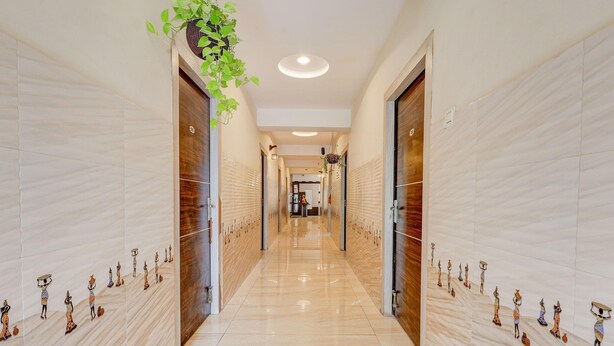 A hallway with a polished floor, wooden doors, and a hanging plant.