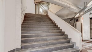 A staircase with a checkered floor pattern leading to a door.